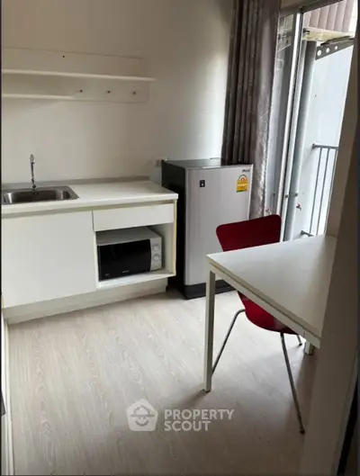 Compact kitchen with modern appliances and dining area in a cozy apartment.