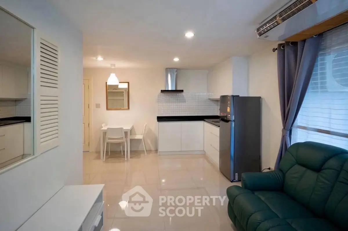 Modern open-plan living room with sleek kitchen and cozy seating area.