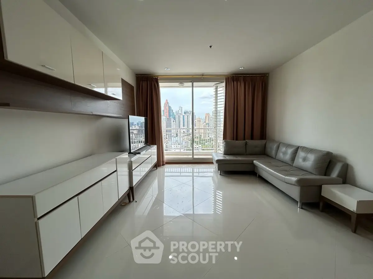 Spacious living room with city view, modern furniture, and large windows in high-rise apartment.