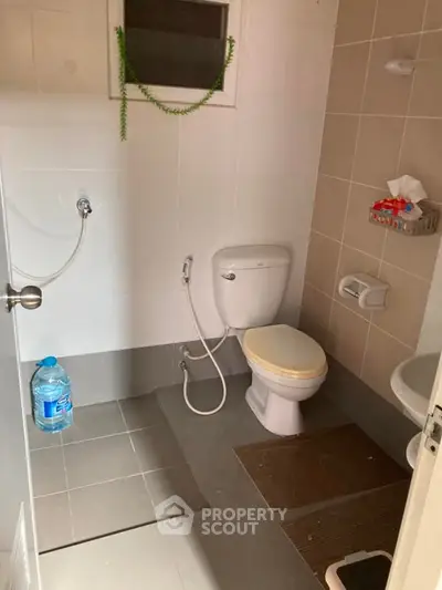 Compact bathroom with essential fixtures and neutral tiles