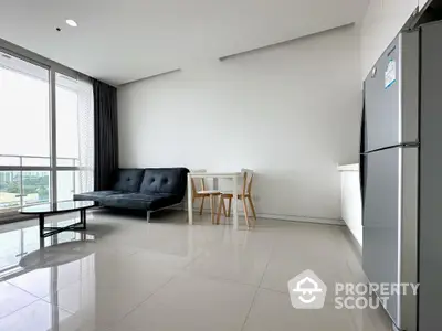 Spacious and modern living room with gleaming tiled floors, a sleek black sofa, and a minimalist dining set, complemented by ample natural light.