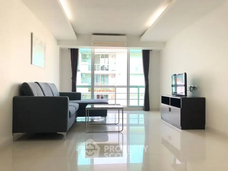 Spacious modern living room with sleek furniture and large window for natural light.