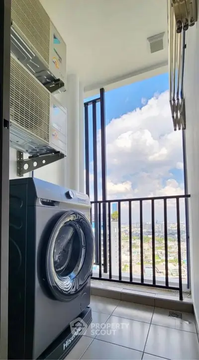 Modern laundry area with washing machine and stunning city view from balcony.