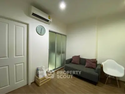 Cozy living room with modern sofa and air conditioning, perfect for relaxation.