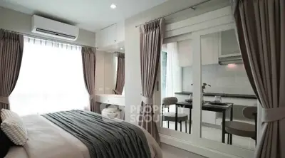 Modern bedroom with elegant decor and view into stylish kitchen
