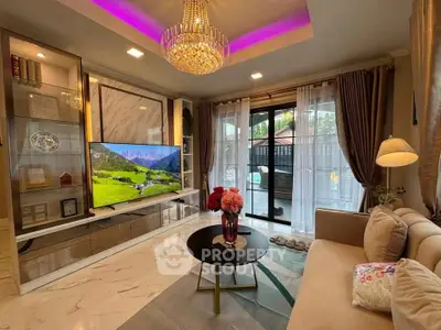 Luxurious living room with elegant chandelier and modern decor, featuring a large TV and stylish furniture.