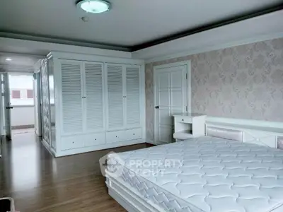 Spacious bedroom with elegant white furniture and ample closet space, perfect for modern living.