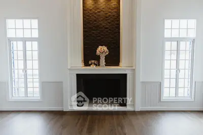 Elegant living room with dark accent fireplace and large windows