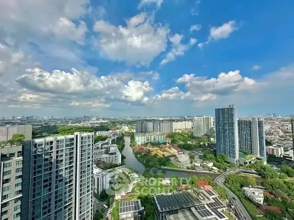 Stunning cityscape view from high-rise building with lush greenery and river, perfect for urban living.