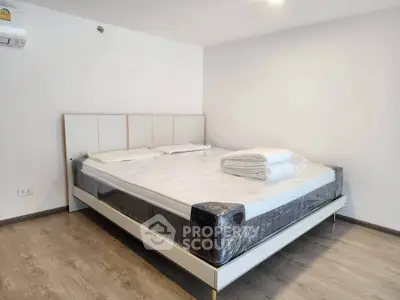 Spacious bedroom with modern bed and wooden flooring