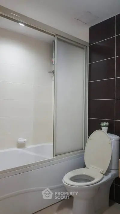 Modern bathroom with sleek design and bathtub in contemporary apartment.