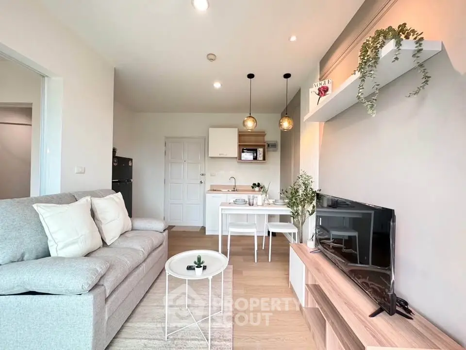 Modern living room with cozy sofa, stylish decor, and open kitchen layout in a bright apartment.