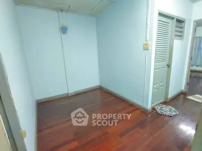 Spacious empty room with wooden flooring and neutral walls, ideal for customization.