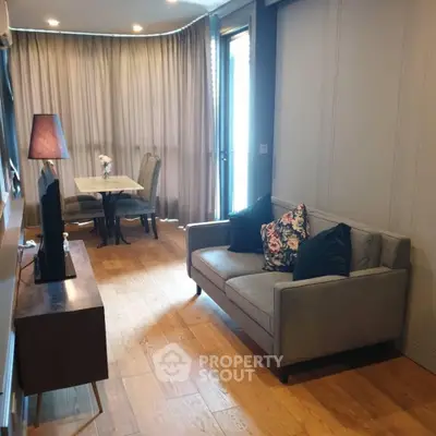 Stylish living room with cozy sofa and elegant dining area, perfect for modern living.