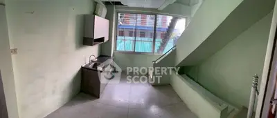 Compact kitchen area with staircase and large window view