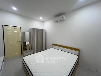 Modern bedroom with minimalist design featuring a comfortable bed and sleek wardrobe.