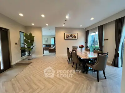 Spacious modern dining room with elegant decor and large windows offering natural light.