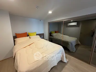 Cozy bedroom with mirrored closet and modern decor in a stylish apartment.