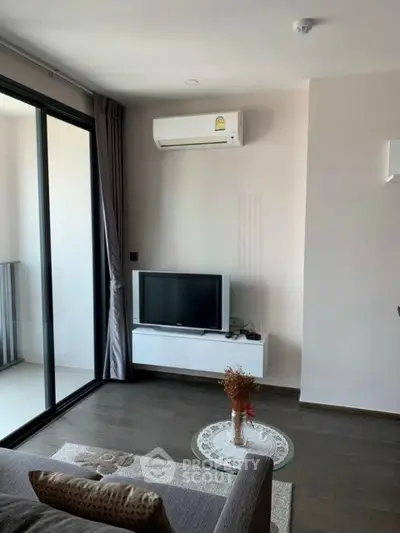Modern living room with balcony access and sleek air conditioning unit.