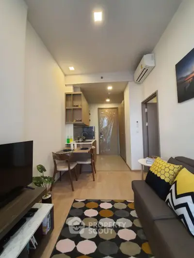 Modern living room with stylish decor and open kitchen layout in a cozy apartment.