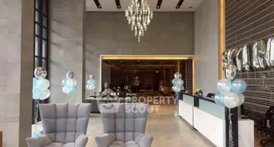 Luxurious lobby with elegant chandelier and modern seating in upscale building.