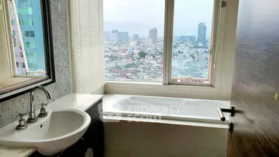 Luxurious bathroom with city view and modern bathtub in high-rise apartment.