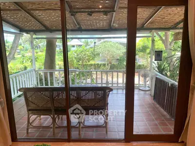 Charming patio with rustic wooden furniture and lush garden view, perfect for relaxing outdoors.