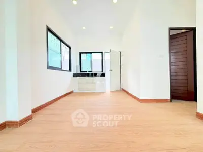 Spacious and bright interior with modern wooden flooring and ample natural light, perfect for a cozy living space.