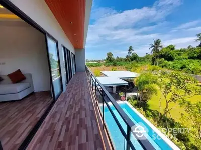 Expansive balcony with breathtaking views, modern design, and seamless indoor-outdoor living in a lush tropical setting.