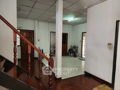 Spacious interior with wooden staircase and tiled flooring, ideal for family living.