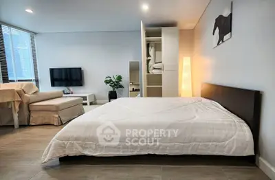 Spacious modern bedroom with cozy seating area and stylish decor