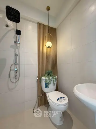 Modern bathroom with sleek shower, stylish pendant light, and elegant wall paneling.