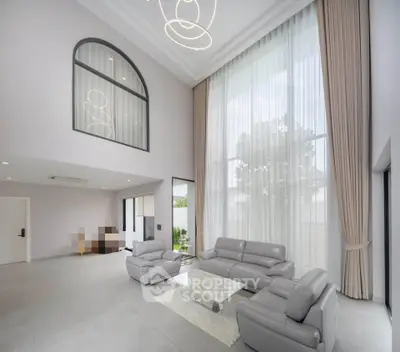 Luxurious high-ceiling living room with modern furniture and large windows.