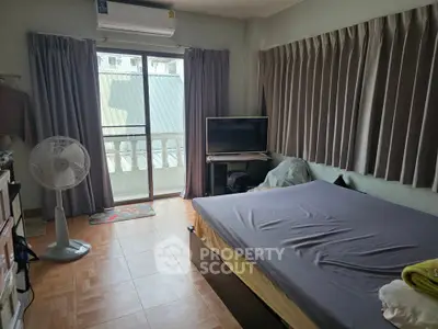Cozy bedroom with balcony access, featuring a large bed, TV, and air conditioning for comfort.