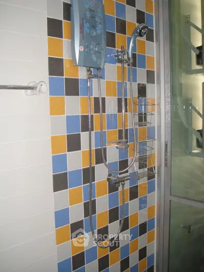 Modern bathroom shower with colorful tile design and sleek fixtures.