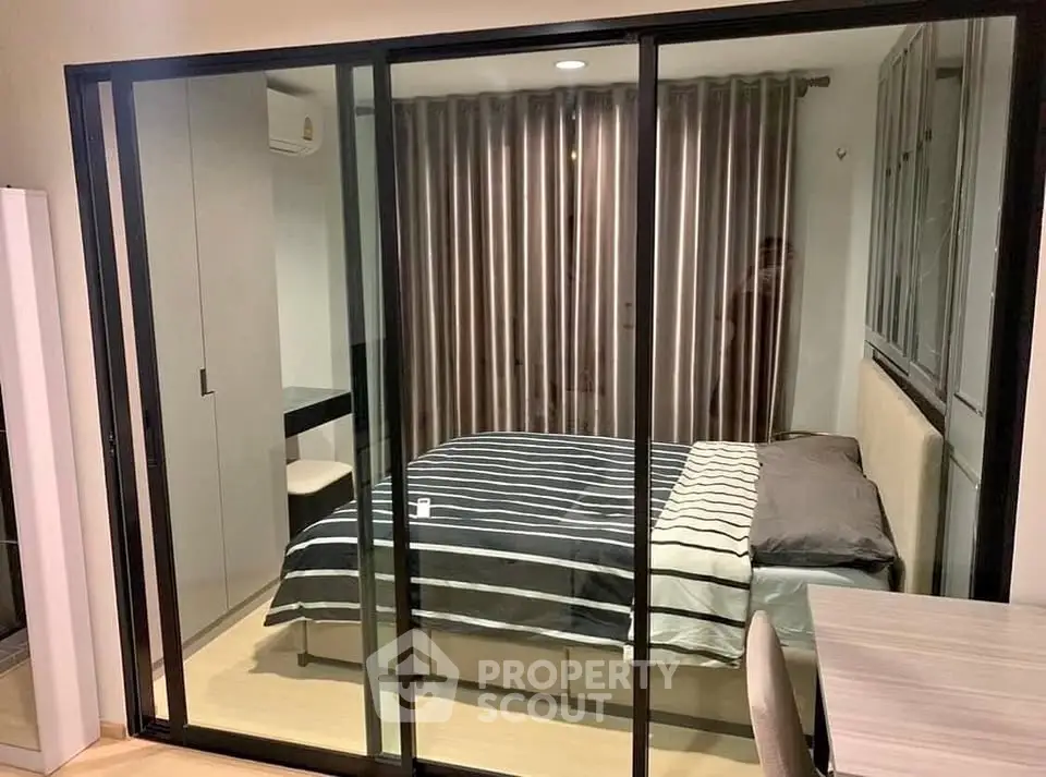 Modern bedroom with glass sliding doors and stylish decor in a cozy apartment.