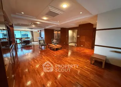 Spacious living room with polished wooden floors and elegant lighting.