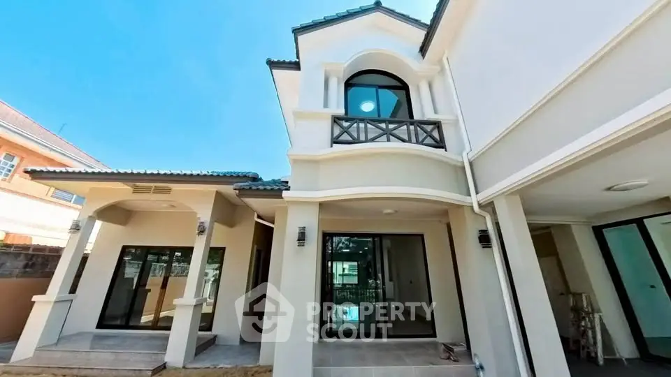 Elegant modern house exterior with large windows and stylish balcony, showcasing contemporary architectural design.