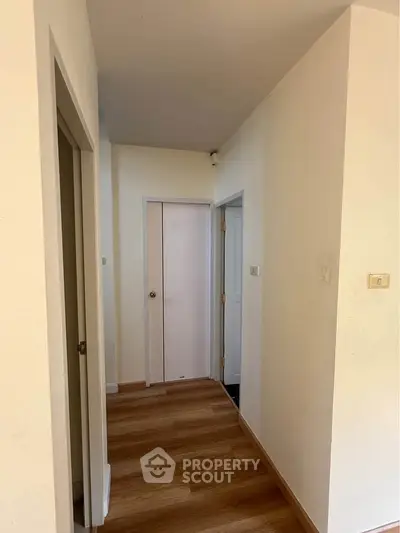 Bright hallway with wooden flooring and white doors in modern home