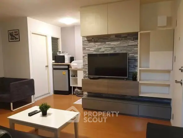 Modern living room with stylish TV unit and cozy seating area, perfect for relaxation and entertainment.