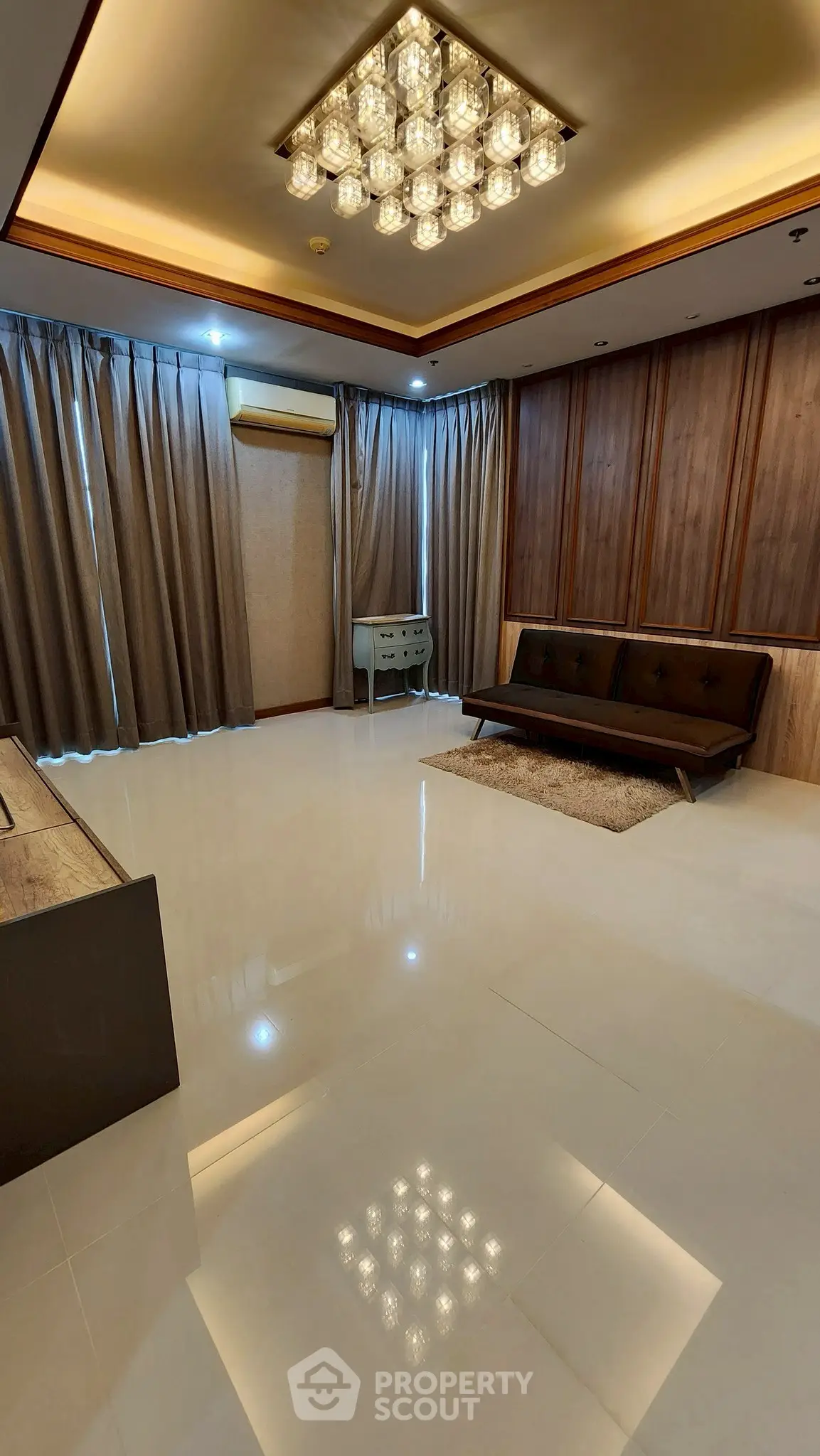 Spacious modern living room with elegant lighting and sleek furnishings.