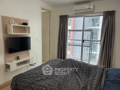 Cozy bedroom with modern decor and balcony view in urban apartment.