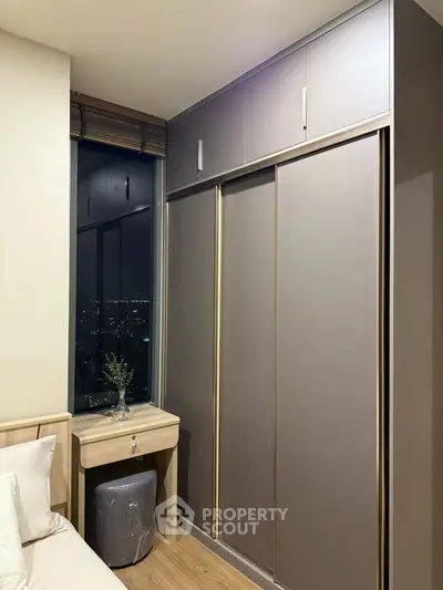 Modern bedroom with sleek wardrobe and city view at night