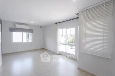 Spacious and bright empty room with large windows and modern blinds, perfect for customization.