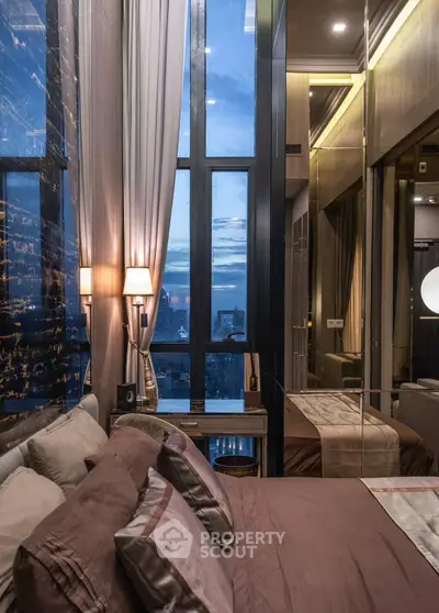Luxurious bedroom with floor-to-ceiling windows offering stunning city views, elegant decor, and ambient lighting.