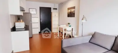 Modern living room with sleek furniture and open kitchen layout in a stylish apartment.