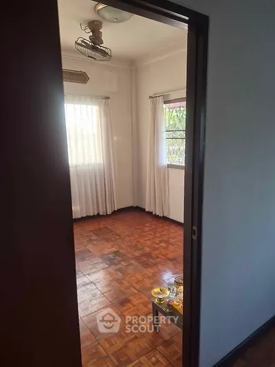 Spacious room with wooden flooring and natural light, ideal for cozy living.