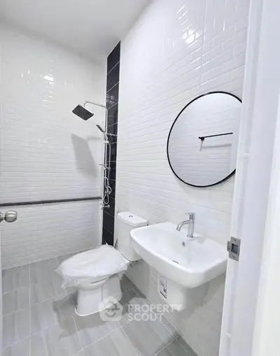 Modern minimalist bathroom with sleek fixtures and white subway tiles.