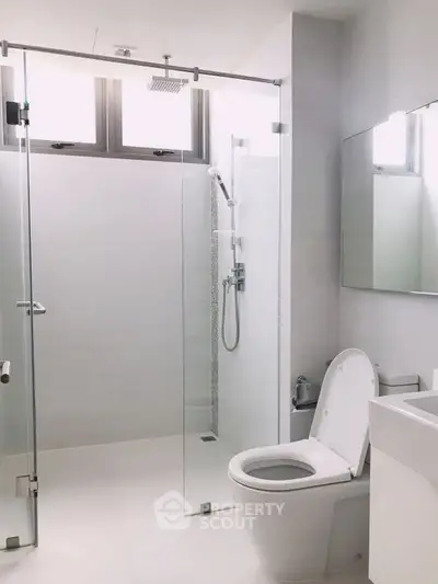 Modern minimalist bathroom with glass shower and sleek fixtures