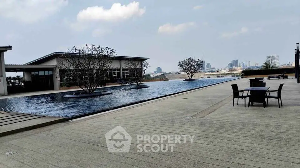 Luxurious rooftop pool with city skyline view and outdoor seating area.